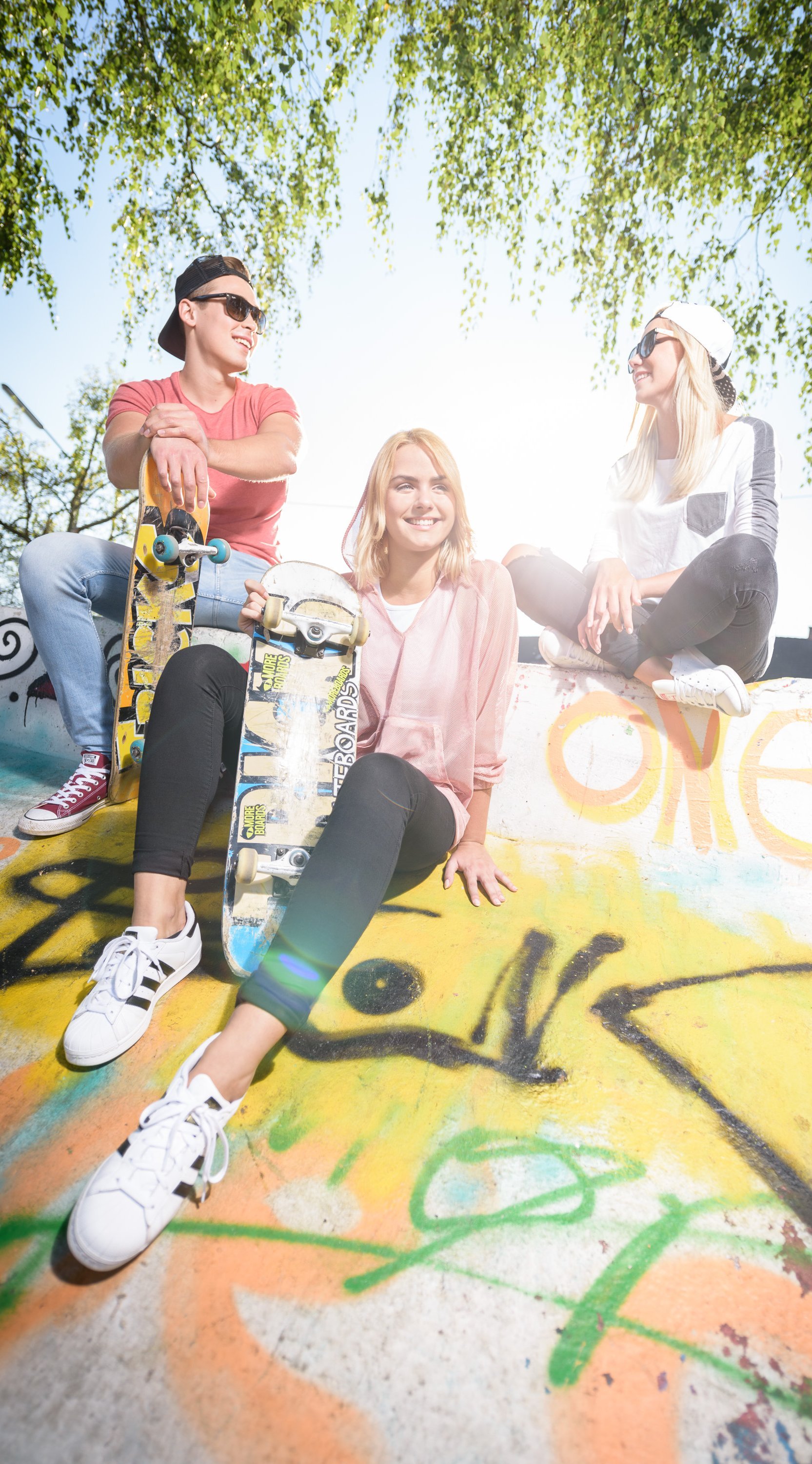 Jugendliche draußen mit Skateboard auf Skateboardrampe 